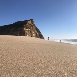 Scenic view of beach against clear blue sky