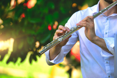 Midsection of man playing flute