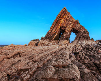 Low angle view of rock formation against blue sky