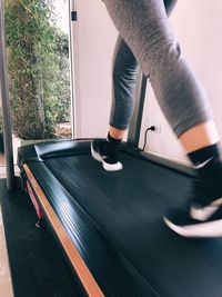 Low section of woman walking on thread mill