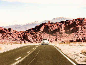 Car on mountain road against sky