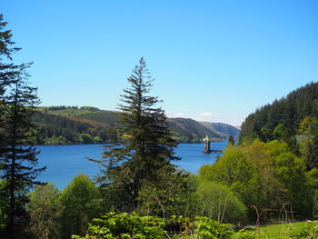 Water tower of lake vyrnwy surrounded by forestry and clear blue skies 