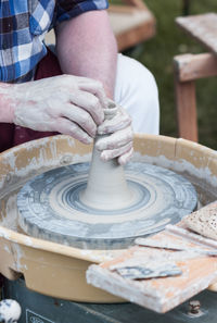 Midsection of man making pottery