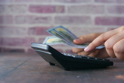 Midsection of person using mobile phone on table