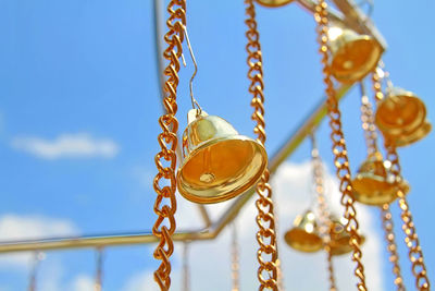 Golden bells hanging on blue sky background