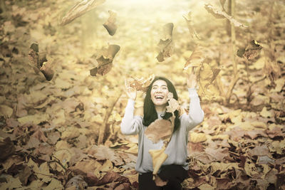 Woman standing with dry leaves