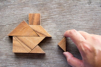 Cropped hands playing with wooden blocks at table