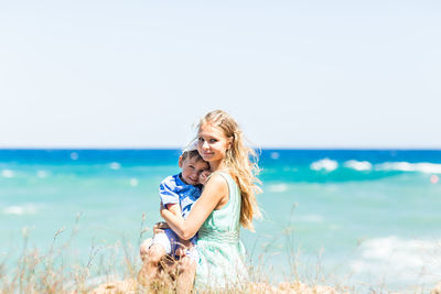 Young woman on shore at beach against sky