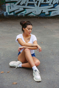 Full length of a young woman sitting outdoors