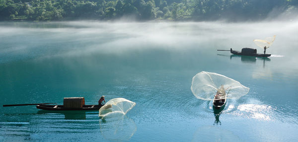 Fishermen throwing net in river