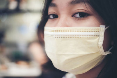 Close-up portrait of young woman covering face