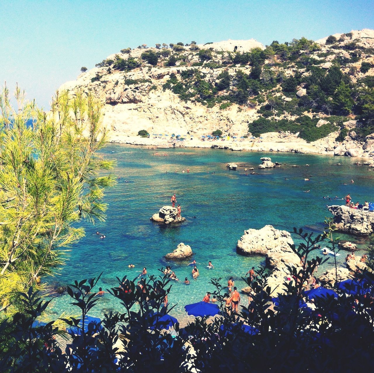 water, sea, blue, nautical vessel, tranquil scene, scenics, tranquility, beauty in nature, nature, boat, clear sky, high angle view, transportation, tree, mode of transport, rock - object, mountain, rock formation, beach, day