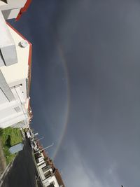 Low angle view of rainbow over buildings in city