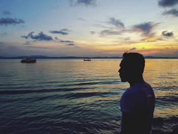 Rear view of man looking at sea against sky