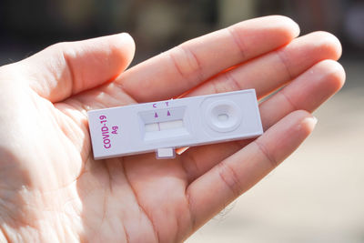 Cropped hand of person holding covid test kit