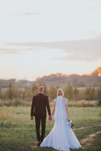 Rear view of couple holding hands