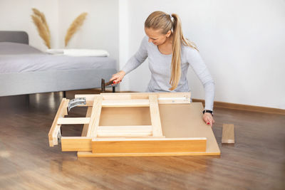 Woman fixing furniture at home