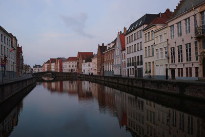 Canal amidst buildings in city, brugge, belgium