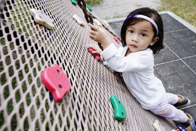 High angle portrait of cute girl climbing on wall