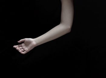 Low section of woman against black background