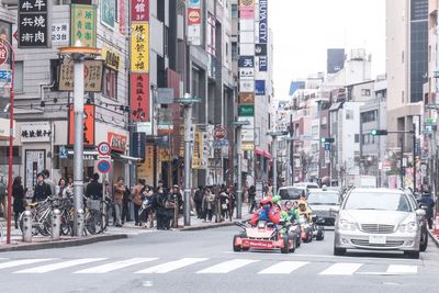 Vehicles on road by buildings in city