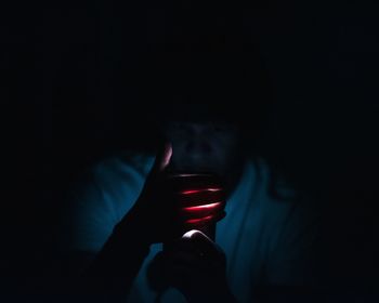 Close-up of young man hand in dark