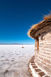 Scenic view of beach against clear blue sky