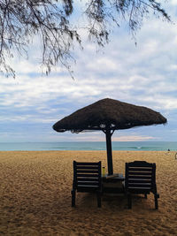 Chair on beach against sky