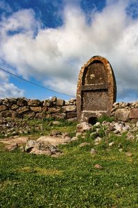 Old ruin on field against sky