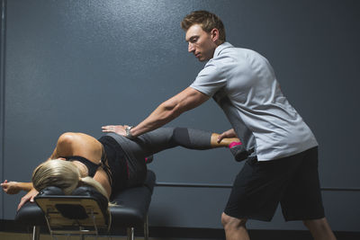 Trainer assisting female customer for exercising