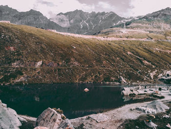 Scenic view of lake by mountains against sky