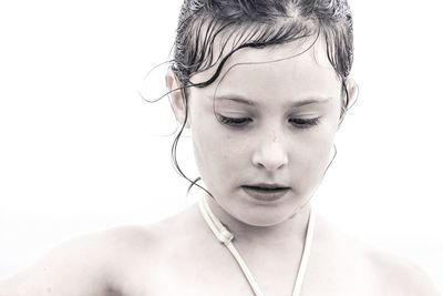 Close-up of girl looking down against white background