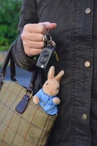 Midsection of woman holding bag and key ring