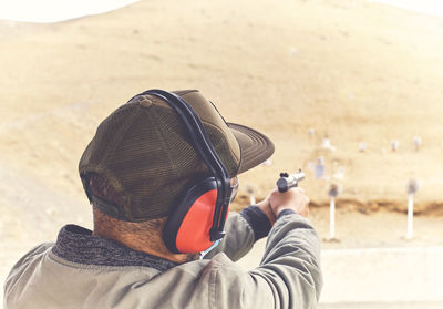 Man with hand gun aiming at shooting range and releasing stress. selective focus