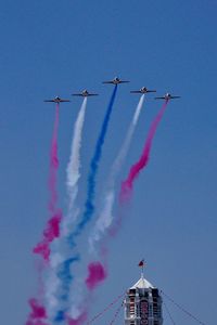 Low angle view of airplane flying against clear blue sky