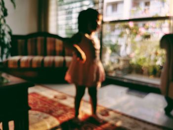 Rear view of woman looking at window