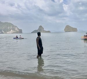 Men on beach against sky