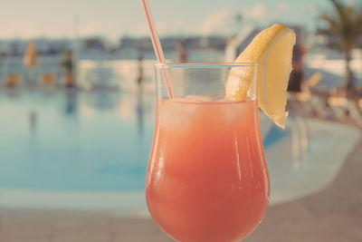 Close-up of drink in glass against swimming pool