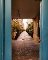 Narrow alley amidst buildings seen through doorway