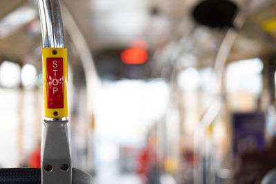 Bus interior in circulation with the stop button in the foreground on a blurred background.