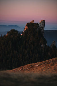 Rock formations on land against sky during sunset