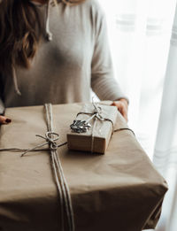 Midsection of woman holding christmas gift