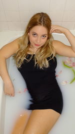 Portrait of young woman relaxing in bathtub