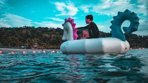 People in swimming pool against sky