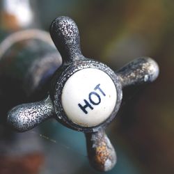 Close-up of hot water shower knob