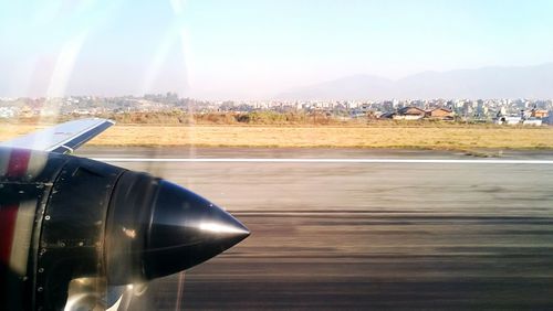 Close-up of airplane on runway against sky