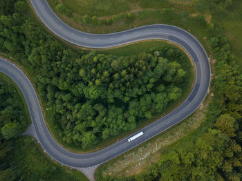 High angle view of winding road amidst green trees