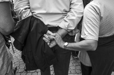 Rear view of couple holding hands behind back