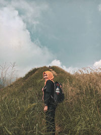 Woman standing on mountain against sky