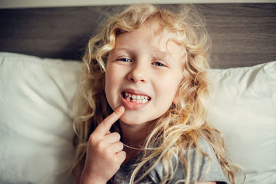 Cute caucasian blonde girl showing her missing tooth in mouth. proud child kid showing lost tooth 